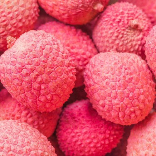 Vibrant close-up of ripe red lychee fruits showcasing their textured skin.