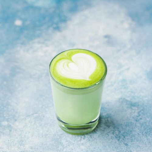 Delectable matcha latte with heart art, captured in a bright and artistic studio setting.